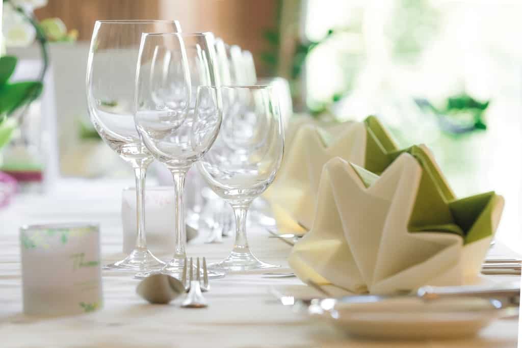 Weingläser auf feierlich gedeckten Tisch im Biorestaurant Retter